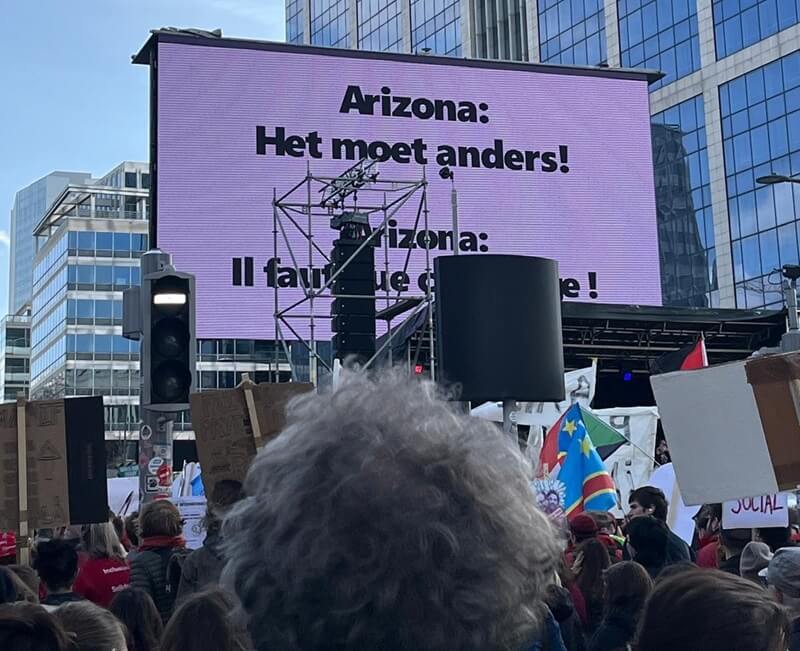 Betogers in Brussel met borden voor een beter opvangbeleid en tegen mensen op straat